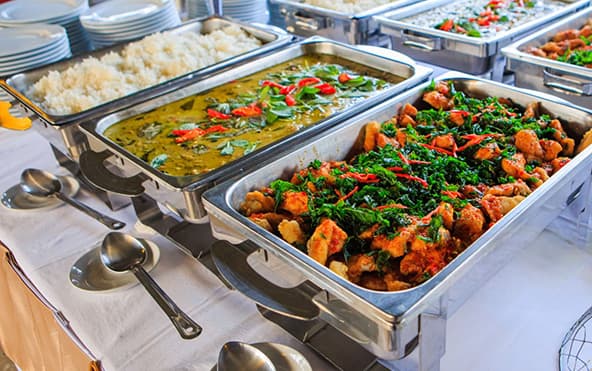 Conference and office event catering in Kolkata — elegant chafing-dish buffet with fresh salads and stacked plates by Parsha Caterer